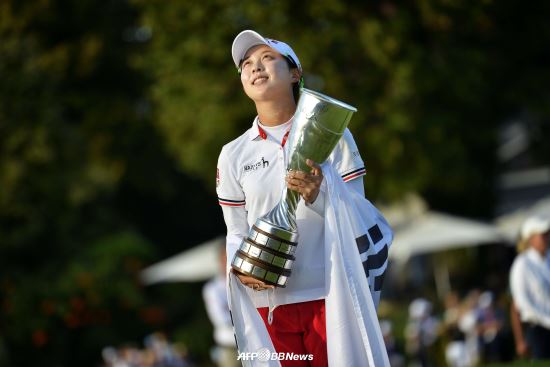 15일(한국시간) 끝난 미국LPGA 투어 에비앙 챔피언십에서 초청선수로 우승한 김효주가 태극기를 두른 채 우승컵을 들고 애국가를 경청하고 있다. AFPBBNews=News1